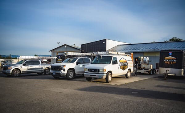The Medford Elite Gutters vehicle fleet sits majestically outside of a project site.